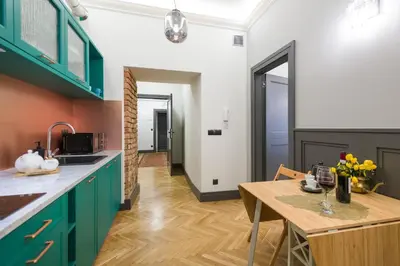 a kitchen with green cabinets and a wooden table at LUXURY Apartment at the Main Square in Kraków