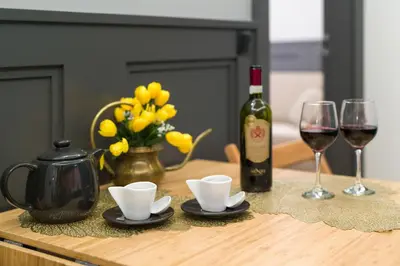 a table with a bottle of wine and two glasses at LUXURY Apartment at the Main Square in Kraków