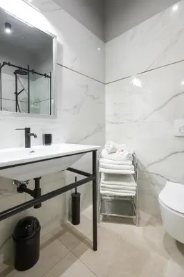 a white bathroom with a sink and a toilet at LUXURY Apartment at the Main Square in Kraków