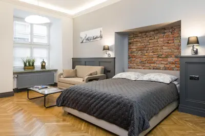 a bedroom with a large bed and a brick wall at LUXURY Apartment at the Main Square Tomasza street in Kraków