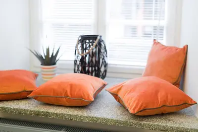 four orange pillows sitting on a window sill at LUXURY Apartment at the Main Square Tomasza street in Kraków