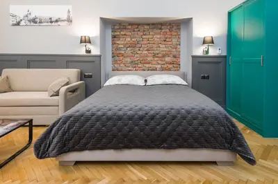 a bedroom with a bed and a brick wall at LUXURY Apartment at the Main Square Tomasza street in Kraków