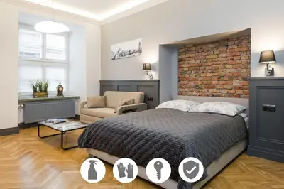 a bedroom with a bed and a brick wall at LUXURY Apartment at the Main Square Tomasza street in Kraków