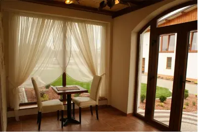 a dining room with a table and chairs and a window at A-Prim in Oświęcim