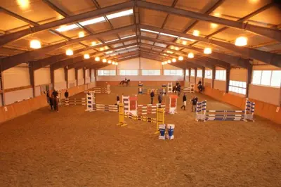 a large arena with people in a horse stable at A-Prim in Oświęcim