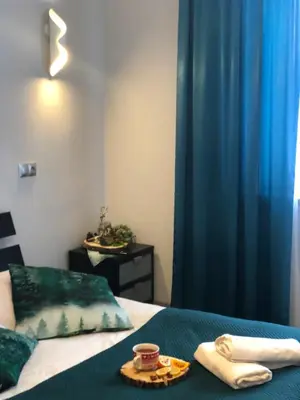 a bedroom with a bed with blue curtains and a tray of food at Hotel Restauracja U Guta in Klikuszowa