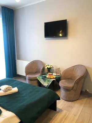 a room with two chairs and a table and a tv at Hotel Restauracja U Guta in Klikuszowa