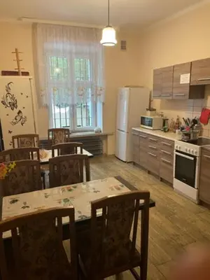 a kitchen with a table and chairs and a refrigerator at Hostel Retro in Kraków