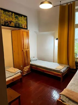 a room with two twin beds and a window at Hostel Retro in Kraków