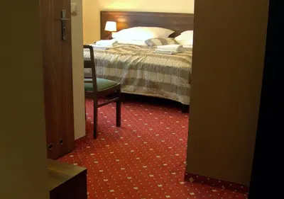 a bedroom with a bed and a chair and a bed at Hotel Kochanów in Kochanów