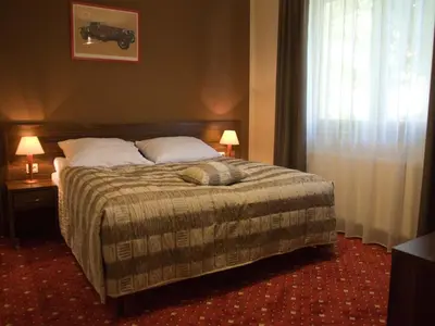 a bedroom with a bed and two lamps and a window at Hotel Kochanów in Kochanów