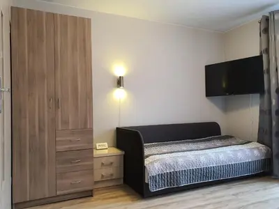 a bedroom with a bed and a cabinet and a television at Pokoje Gościnne in Kraków