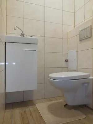 a bathroom with a white toilet and a sink at Pokoje Gościnne in Kraków