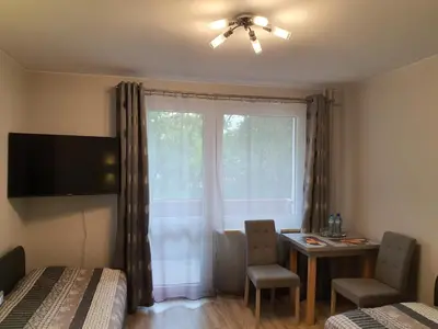 a bedroom with a window with a table and a chair at Pokoje Gościnne in Kraków