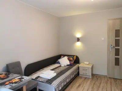 a small bedroom with a bed and a table at Pokoje Gościnne in Kraków