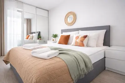 a bedroom with a large bed with towels on it at InPoint Zablocie Modern Apartments for Work&Travel Self Check-in in Kraków