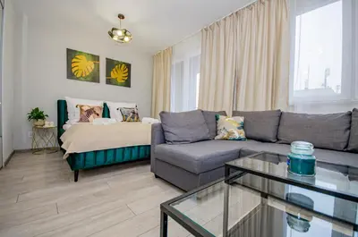a living room with a couch and a table at InPoint Zablocie Modern Apartments for Work&Travel Self Check-in in Kraków