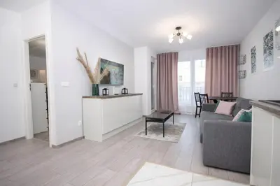 a living room with a couch and a table at InPoint Zablocie Modern Apartments for Work&Travel Self Check-in in Kraków