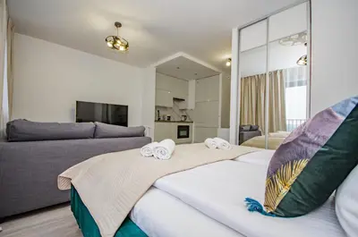 a bedroom with two beds and a couch at InPoint Zablocie Modern Apartments for Work&Travel Self Check-in in Kraków