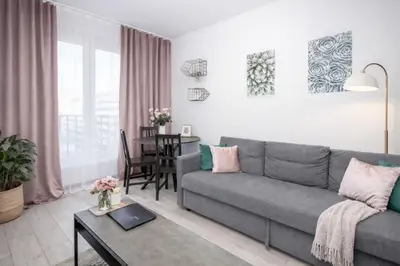 a living room with a couch and a table at InPoint Zablocie Modern Apartments for Work&Travel Self Check-in in Kraków