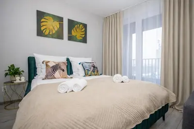 a bedroom with a large bed with towels on it at InPoint Zablocie Modern Apartments for Work&Travel Self Check-in in Kraków