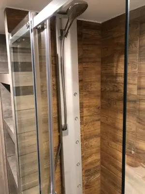 a shower in a bathroom with wooden walls at FANTAZJA in Spytkowice