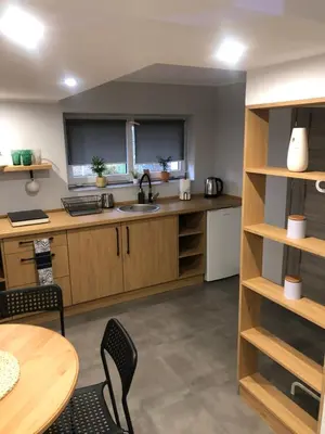 a kitchen with wooden cabinets and a table and chairs at FANTAZJA in Spytkowice