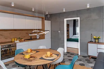 a kitchen and dining room with a table and chairs at 3D KOSCIUSZKI 19 Apartament in Kraków
