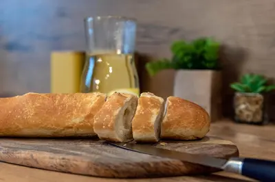 a loaf of bread on a cutting board with a knife at 3D KOSCIUSZKI 19 Apartament in Kraków