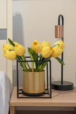 a vase filled with yellow flowers on a table at 3D KOSCIUSZKI 19 Apartament in Kraków