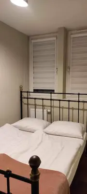 a bedroom with two beds with white sheets and two windows at 3D KOSCIUSZKI 19 Apartament in Kraków