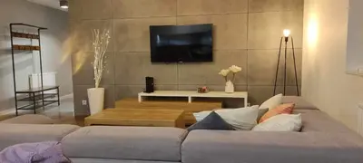 a living room with a couch and a tv on a wall at 3D KOSCIUSZKI 19 Apartament in Kraków