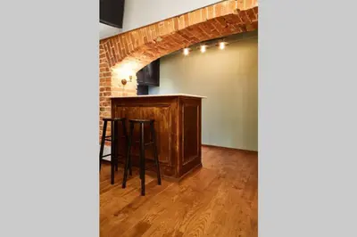 an empty room with a bar and a brick wall at HOUSEHOST Apartment II: Studencka Street in Kraków