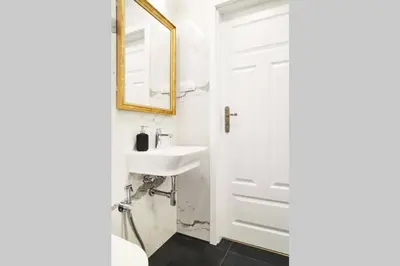 a white bathroom with a sink and a mirror at HOUSEHOST Apartment II: Studencka Street in Kraków