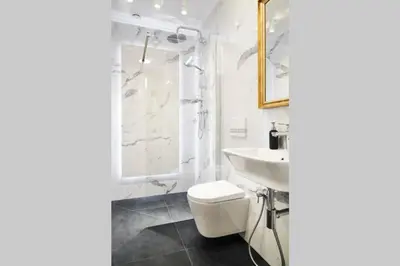a white bathroom with a toilet and a sink at HOUSEHOST Apartment II: Studencka Street in Kraków