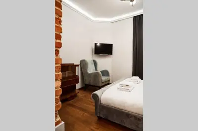 a hotel room with a bed and a chair at HOUSEHOST Apartment II: Studencka Street in Kraków
