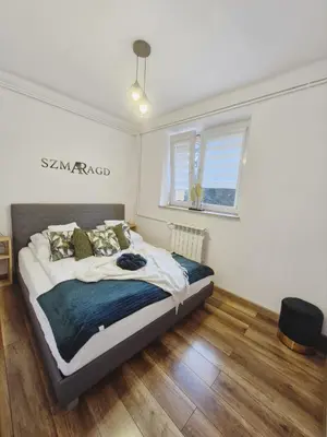 a bedroom with a bed and a window at Szmaragd in Rabka