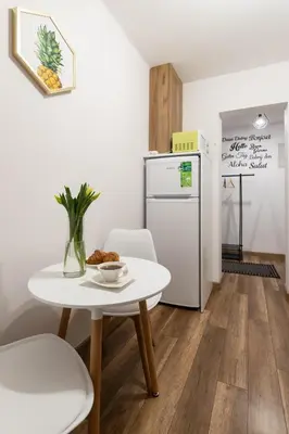 a small kitchen with a table and a refrigerator at Szmaragd in Rabka