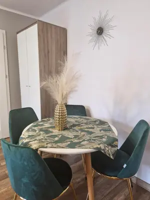 a dining room table with green chairs and a pineapple on it at Szmaragd in Rabka