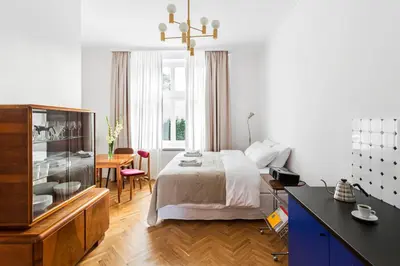 a bedroom with a bed and a desk and a table at Wesoła by Landmark Apartments in Kraków