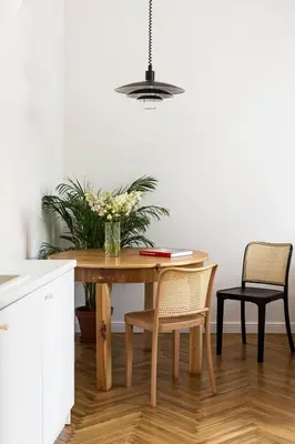 a dining room table with chairs and a vase of flowers at Wesoła by Landmark Apartments in Kraków