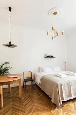 a white bedroom with a bed and a table at Wesoła by Landmark Apartments in Kraków