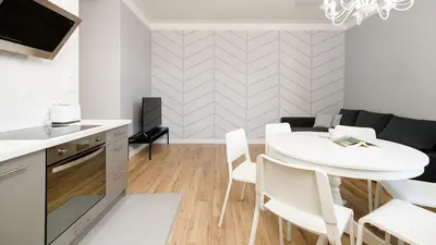 a kitchen and dining room with a white table and chairs at Native Apartments Blich 7 in Kraków