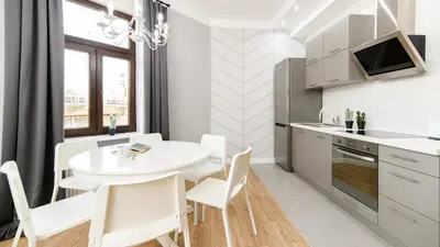 a kitchen and dining room with a white table and chairs at Native Apartments Blich 7 in Kraków