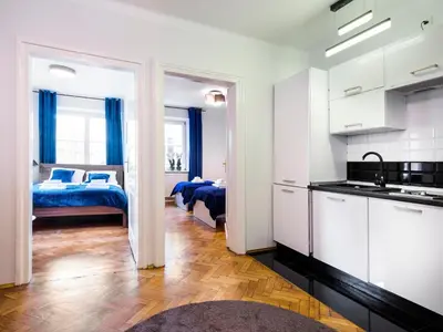 a room with a kitchen and a bedroom with a bed at CracWoW St. Thomas Apartment in Kraków