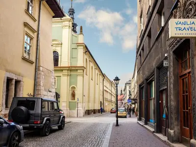 a car parked on a street next to buildings at CracWoW St. Thomas Apartment in Kraków
