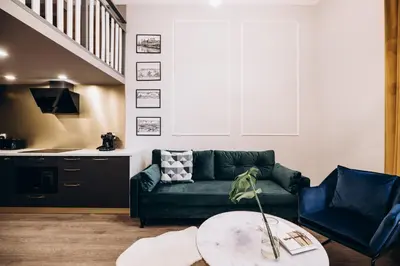 a living room with a green couch and a table at Native Apartments Paulińska 20 in Kraków