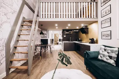 a living room and kitchen with a staircase in a loft at Native Apartments Paulińska 20 in Kraków