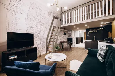 a living room with a couch and a tv on a wall at Native Apartments Paulińska 20 in Kraków