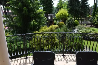 two chairs sitting on a balcony looking at a garden at Apartament DeLuxe 1 in Oświęcim
